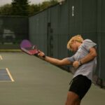 person hitting the pickleball ball