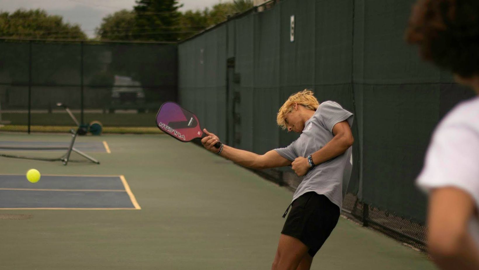 person hitting the pickleball ball